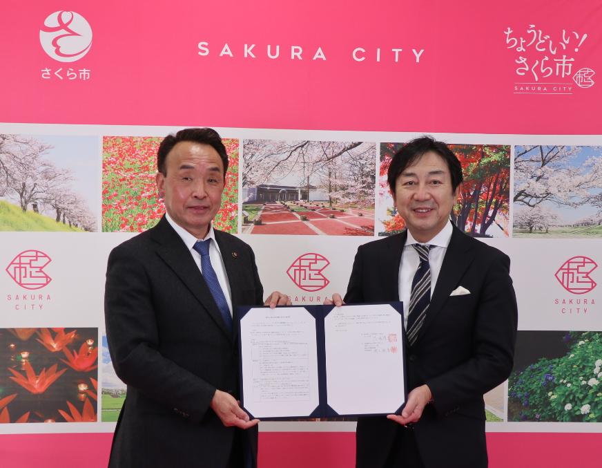 協定書を持つ市長と株式会社鎌倉新書の方の写真