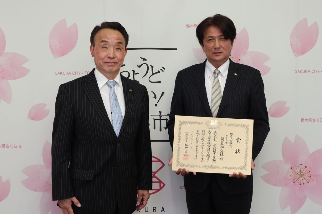 賞状を持つ株式会社和みの杜の高野代表取締役社長と市長の写真