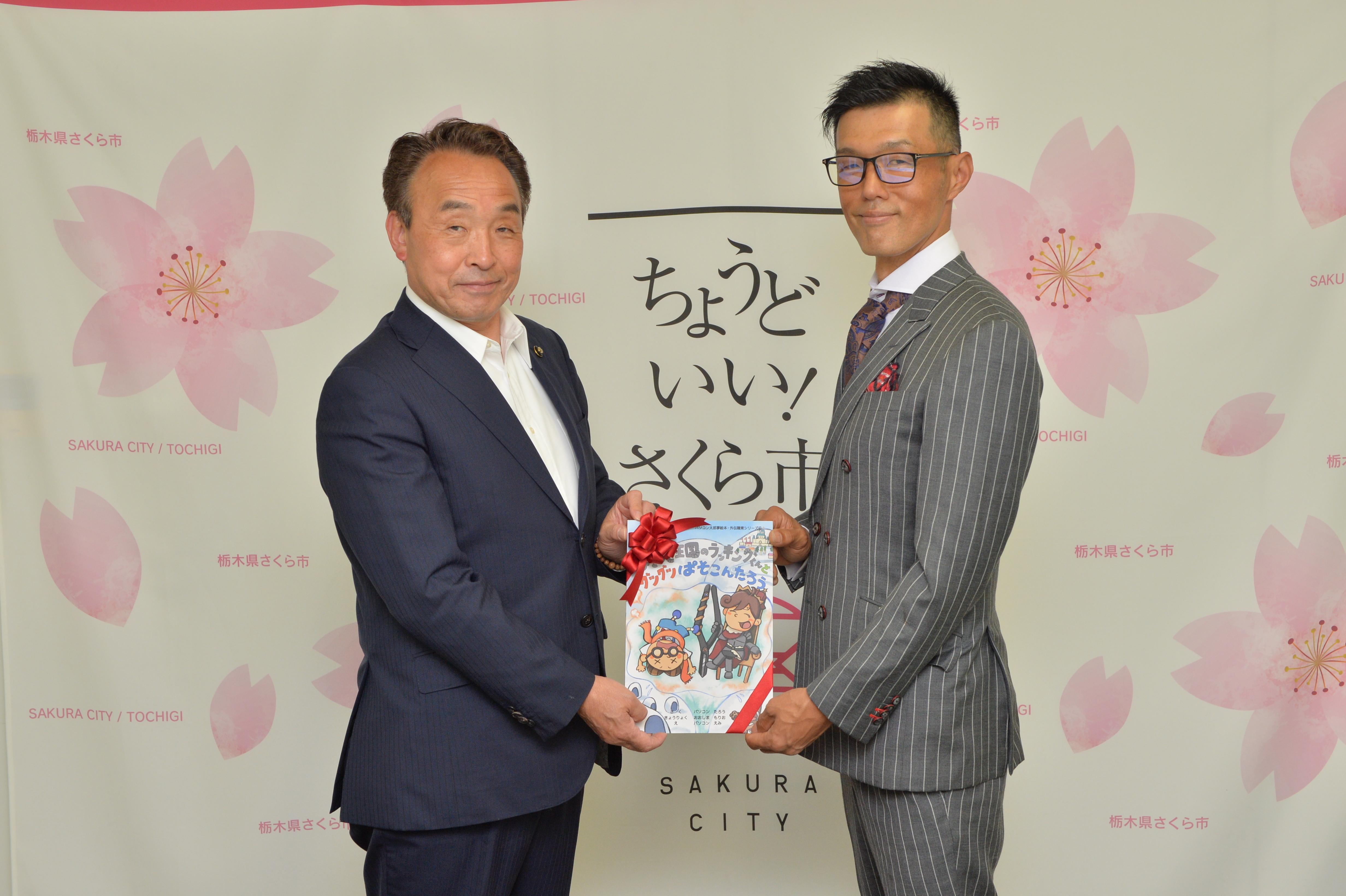 絵本の寄贈を受ける市長・議長・副市長と、（株）大島インシュレーションの代表の方の写真